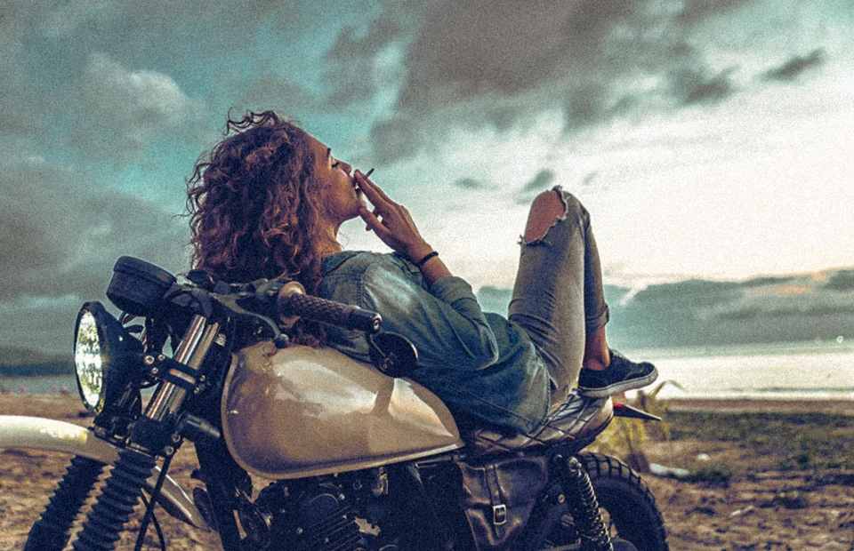 Woman laying back smoking on a motorcycle